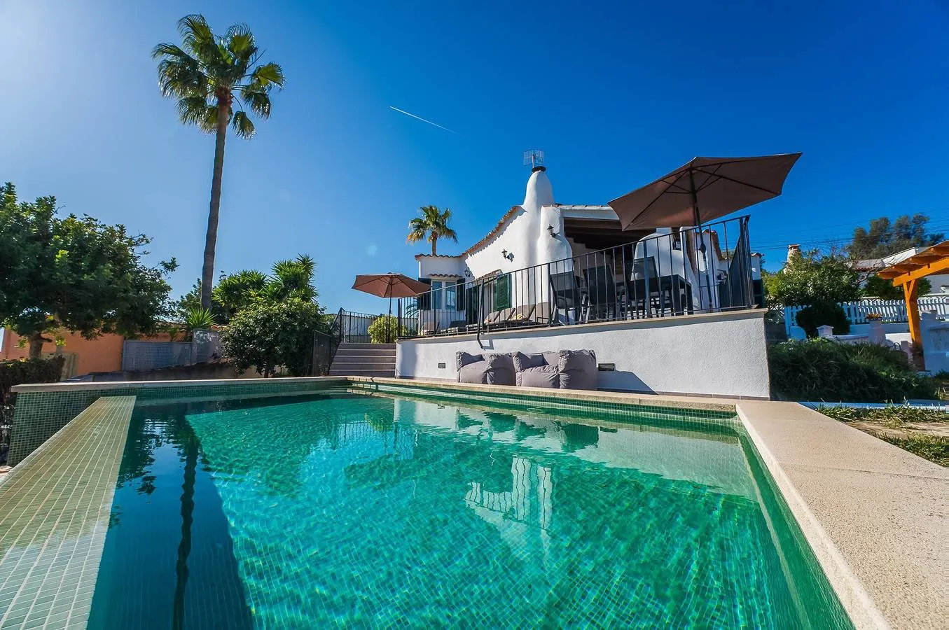 Private infinity pool at Villa Son Bisho with the whitewashed house behind, in Campanet, Mallorca